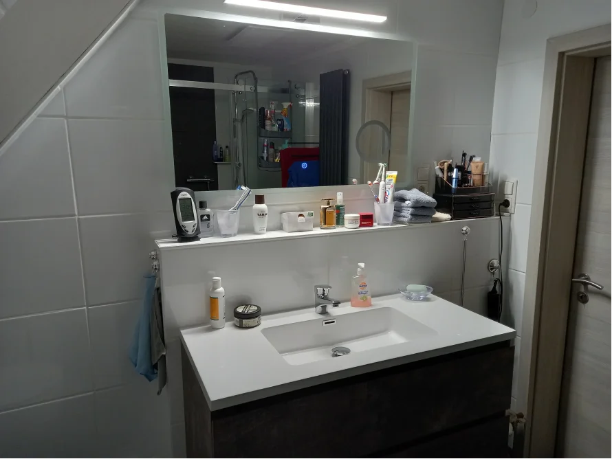 Einblick in ein Badezimmer mit Waschbecken und Spiegel