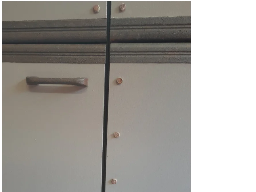 Graue Tür mit Nietenverzierung