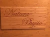 Ein Holzschild mit der Gravur "Natura Physio".