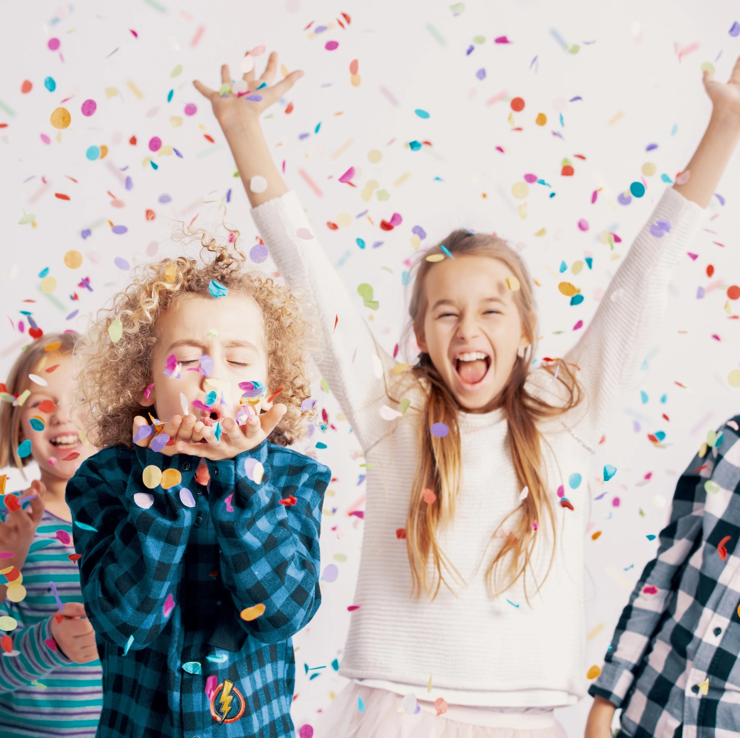Vier Kinder feiern mit Konfetti