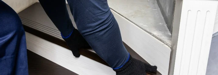 Person bringt Holzverkleidung an