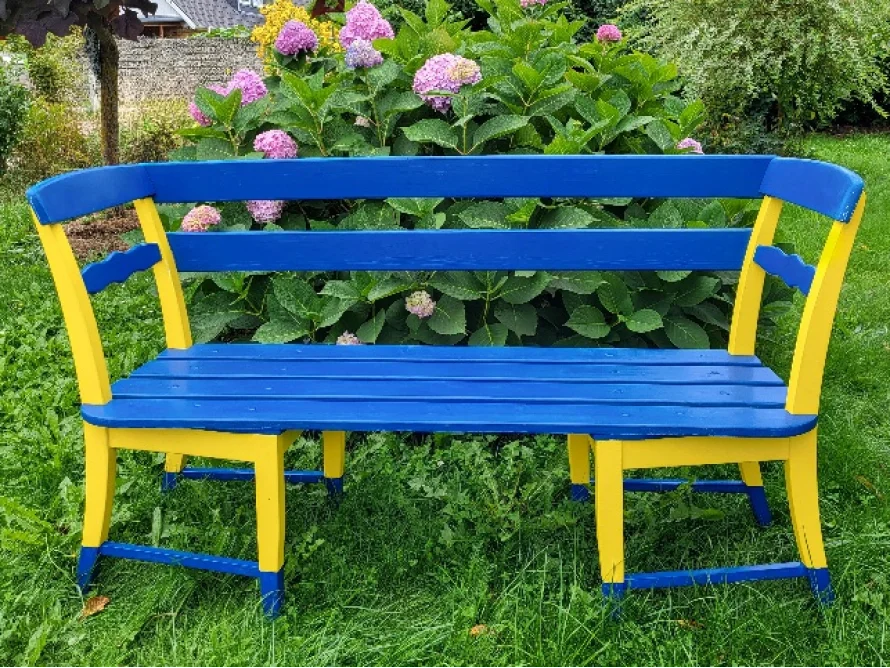Blau-gelbe Gartenbank im Garten