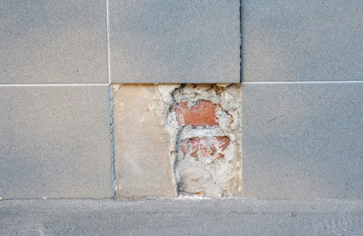 Beschädigte Fliese an einer Wand