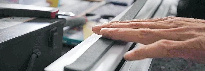 Person drückt Dichtungsgummi an Fensterrahmen