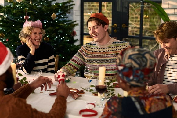 Personen sitzen an Weihnachten zusammen und lachen