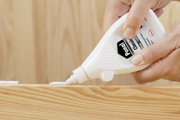 Klebstoff wird auf Holz aufgetragen