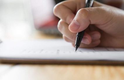 Männliche Hand schreibt auf Dokument