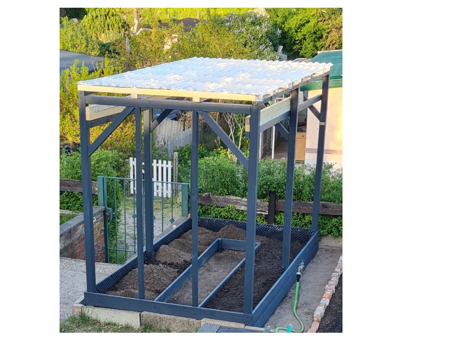 Holzgerüst mit Foliendach über einem Hochbeet