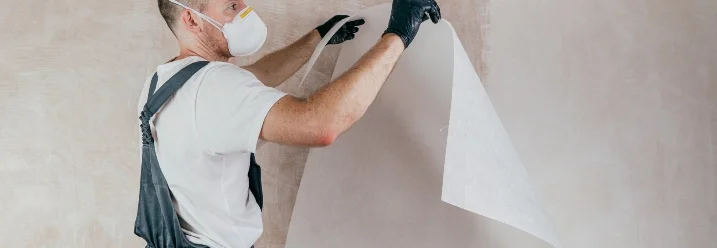 Person bringt Glasfasertapete an