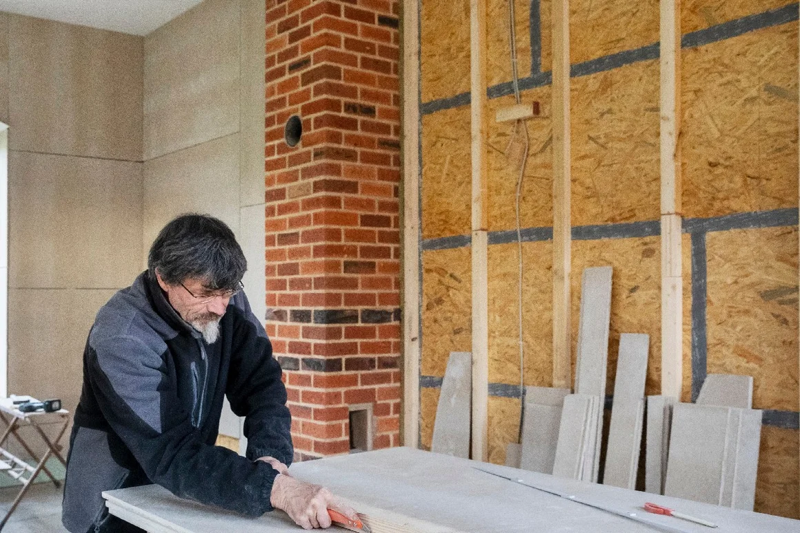 Person schneidet Holz mit Cuttermesser