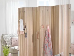 Hölzerner Raumteiler mit Kleidung