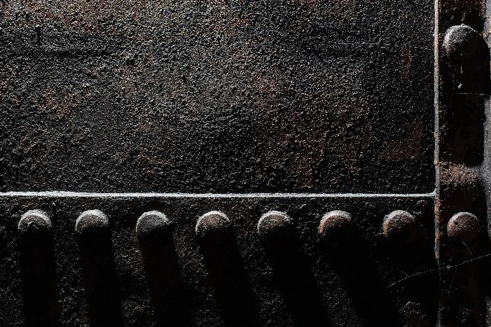 Dunkle Metallplatte mit Nieten