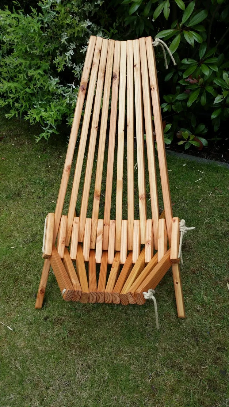 Klappbarer Holzliegestuhl auf Rasen