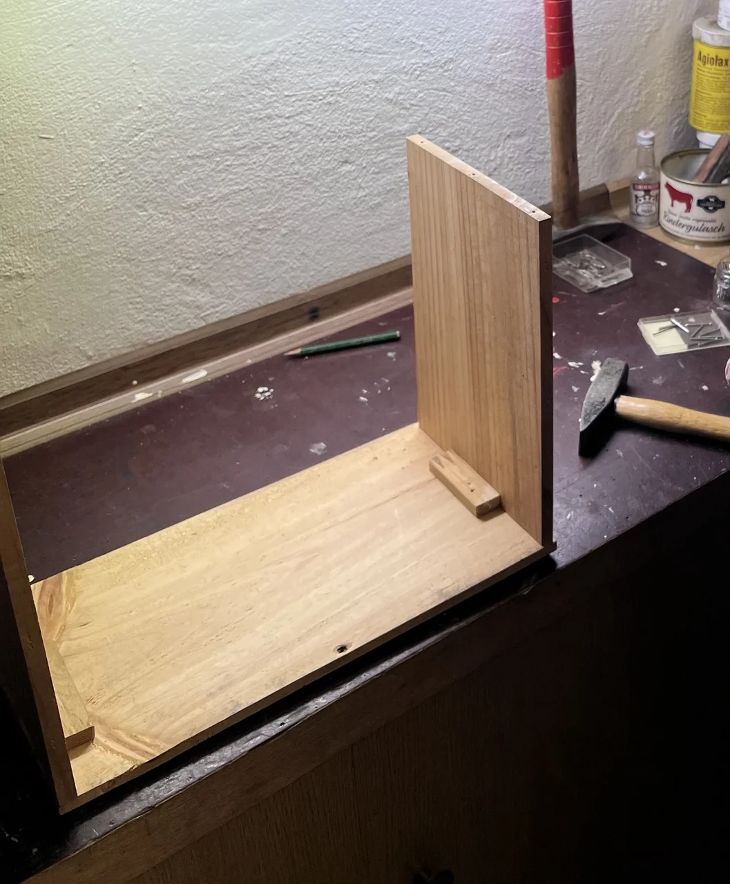 Holzregal im Bau auf einer Werkbank mit einem Hammer.