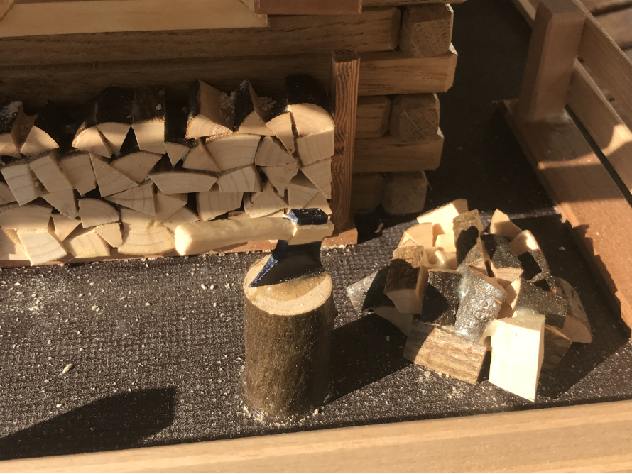 Holzhaus Modell mit Axt und Holzstapel