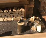 Holzhaus Modell mit Axt und Holzstapel