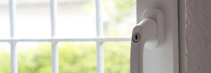 Weißer Fenstergriff an geschlossenem Fenster
