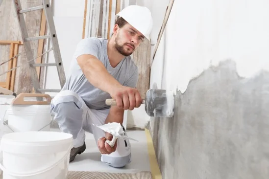 Person verputzt Wand mit Kelle