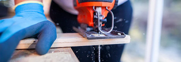 Person sägt Holz mit Stichsäge