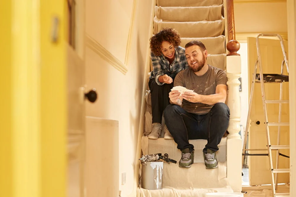 Zwei Personen betrachten Farbkarte auf Treppe