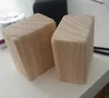 Zwei quaderförmige Möbelfüße aus hellem Holz mit sichtbarer Maserung.