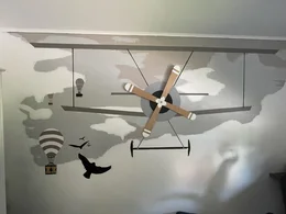 Wanddekoration mit einem Flugzeug, Heißluftballons und Vögeln.