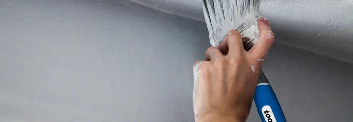 Person streicht Decke weiß