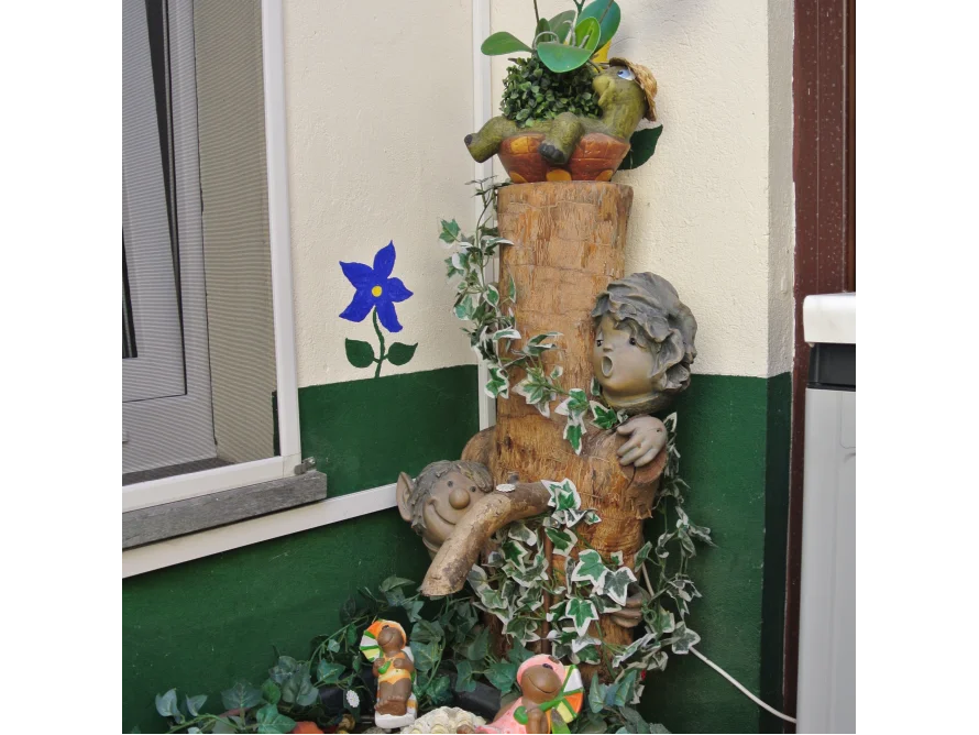 Zwei Gartenzwerge an einem Baumstamm