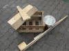 Holzkiste, Bretter und ein Metalleimer auf Pflastersteinen