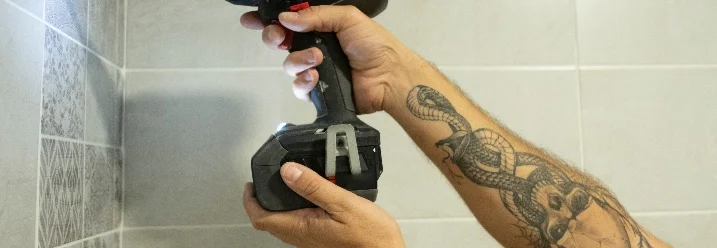 Person bohrt mit Akkuschrauber in Wand