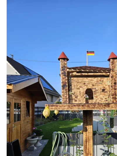 Vogelhaus in Form einer Burg mit deutscher Flagge