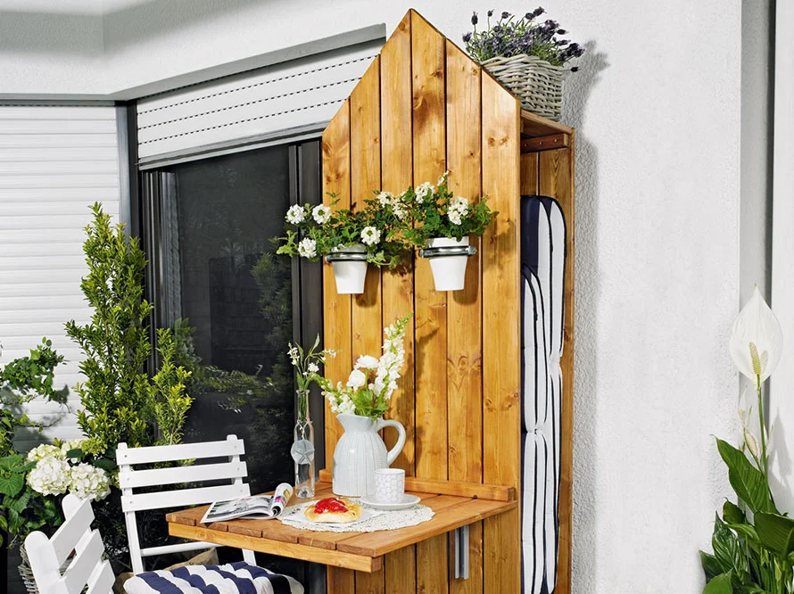 Holz-Sichtschutz mit Klapptisch und Blumen