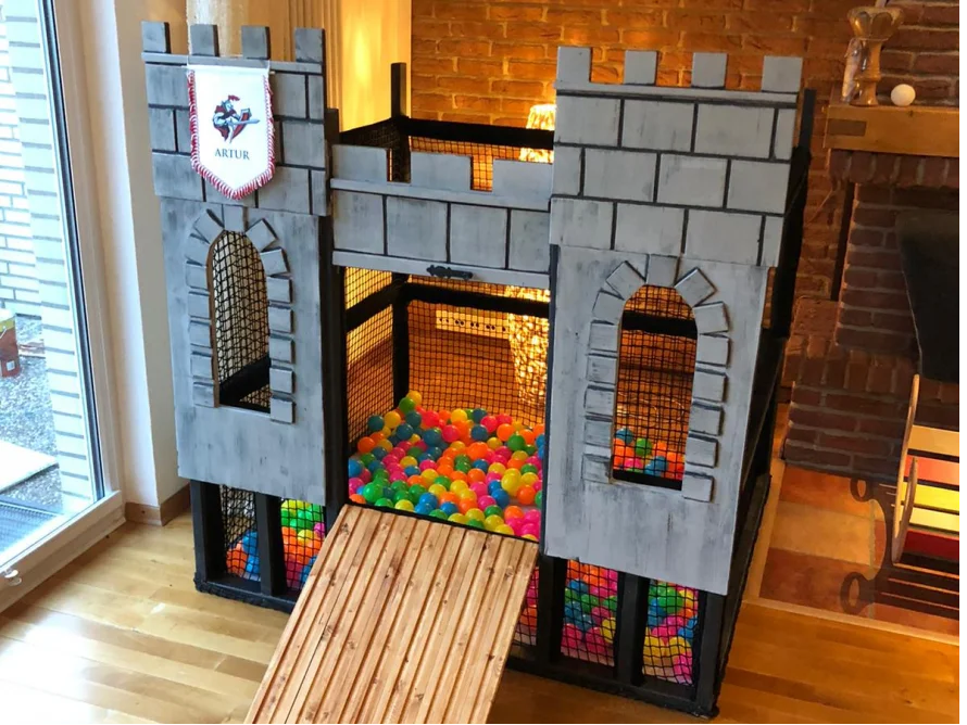 Ein Spielhaus aus Holz gebaut, das wie eine Burg aussieht