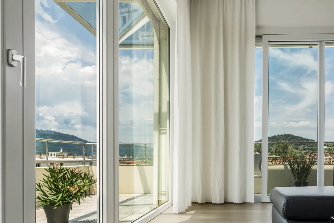 Balkontür mit Blick auf bewaldete Hügel