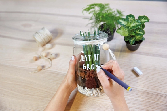 Person beschriftet Glas mit Stift