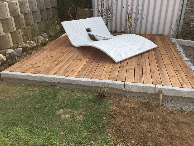 Holzterrasse mit weißer Liege