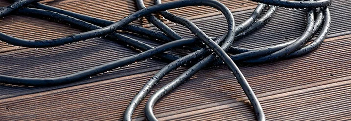 Schwarzer Schlauch auf Holzdielen