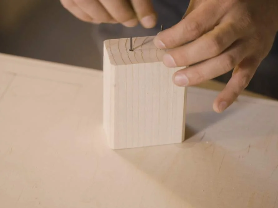 Zwei Nägel in Holz schlagen