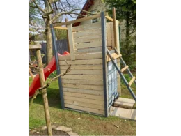 Spielhaus aus Holz mit roter Rutsche