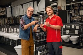 Martin Brambach und toom Mitarbeiter mit Siphon in der Hand. 