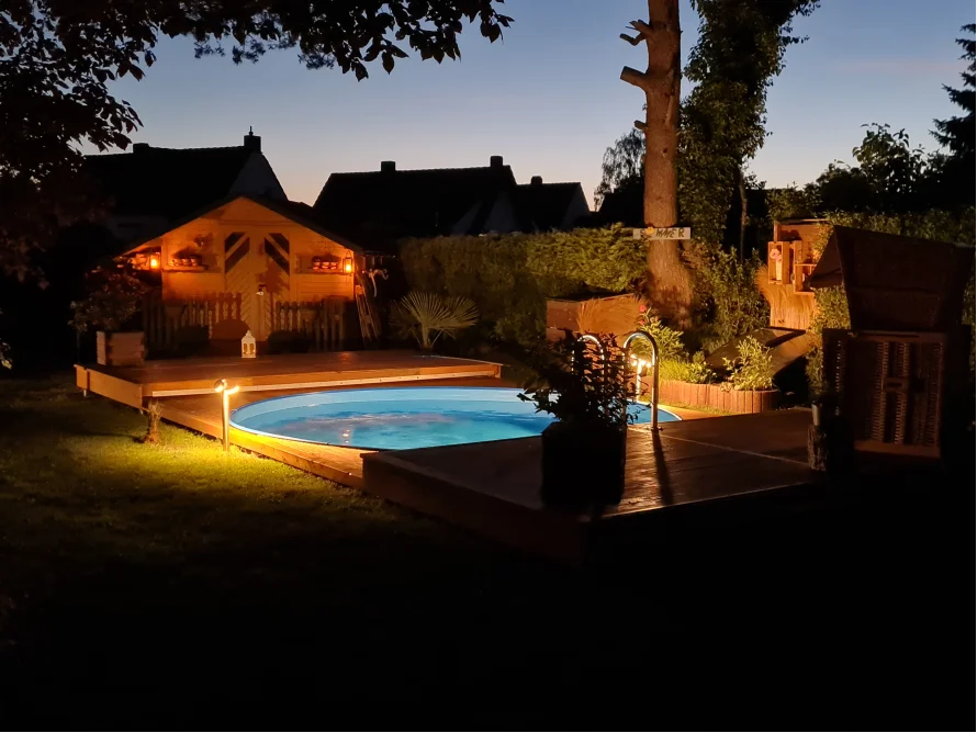 Pool auf einer Terrasse mit Gartenbeleuchtung