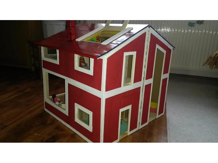 Zweistöckiges rotes Puppenhaus mit weißen Fensterrahmen