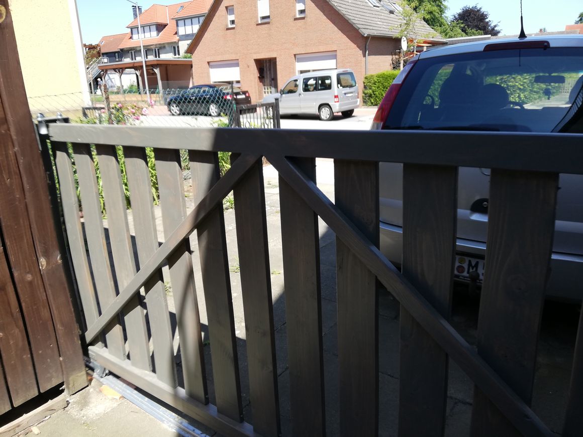 Graues Holztor mit diagonalen Latten