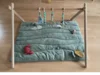 Ein Baby-Spielbogen aus Holz mit Spielzeug.