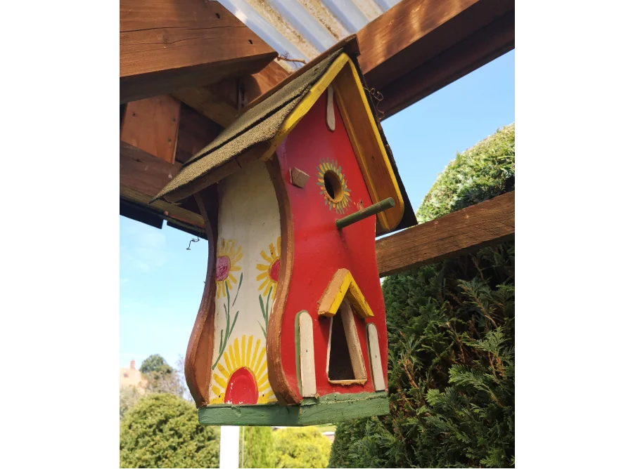 Ein buntes Vogelhaus mit Sonnenblumenmuster