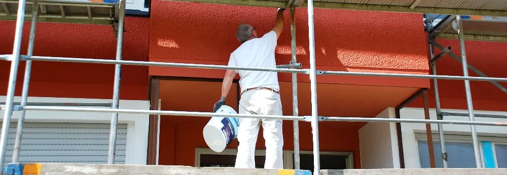 Person streicht Hauswand