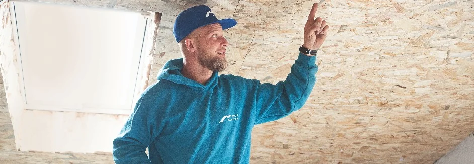 Person zeigt auf Dachkonstruktion