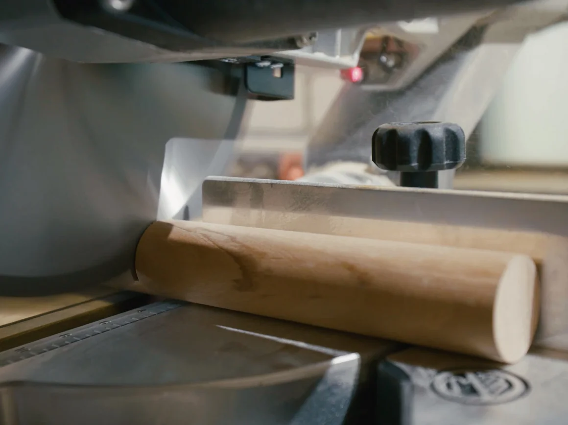 Kreissäge schneidet Holzzylinder.