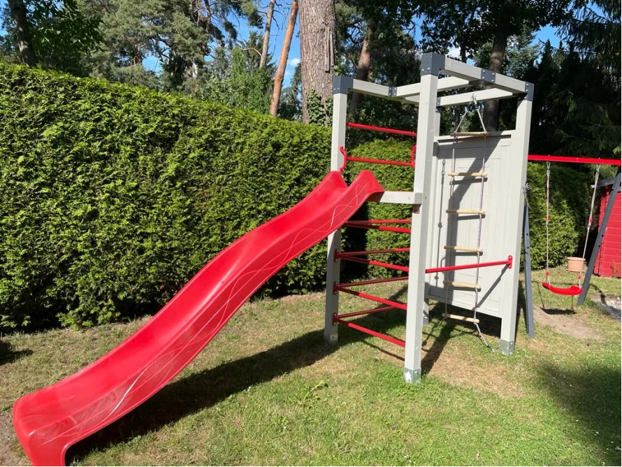 Kleines Spielgerüst mit roter Rutsche