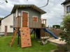 Spielhaus aus Holz mit Rutsche und Kletterwand